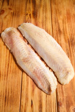 Ahşap zeminde çiğ morina filetosu.