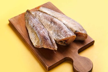 Sarı arka planda çiğ morina balığı olan ahşap tahta tahta.