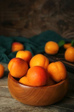 Ahşap masa üzerinde taze kayısı ile kase