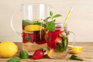Mason kavanozu ve ahşap masada çilekli taze limonata.