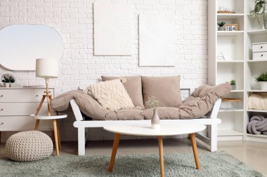 Oturma odasının içinde kanepe, sehpa ve ayna var.