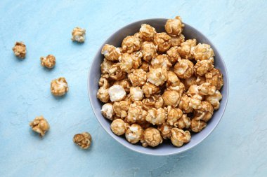 Mavi arka planda lezzetli patlamış mısır kasesi