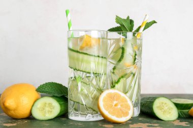 Yeşil masada salatalıklı limonata ve nane şekeri.