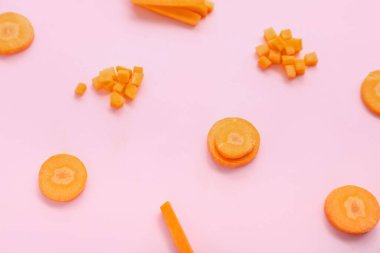Pembe arka planda taze havuç dilimleri