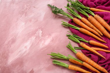 Pembe arka planda bir sürü taze havuç