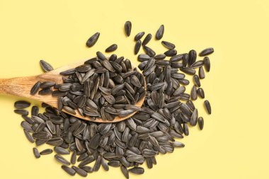 Sarı arka planda ayçiçeği tohumlu kaşık