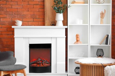 Kaliteli şömine ve tuğla duvarın yanındaki raflar.