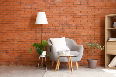 Oturma odasının içinde şık gri koltuk ve kahve masası.