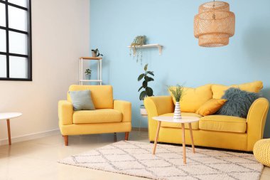 Oturma odasında rahat bir koltuk, kanepe ve masa.