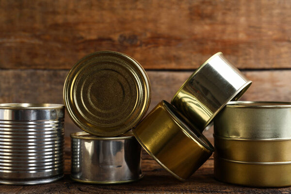 Different tin cans with fish on wooden table