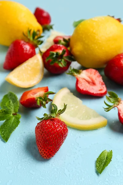 Ingredients for preparing strawberry lemonade on blue background