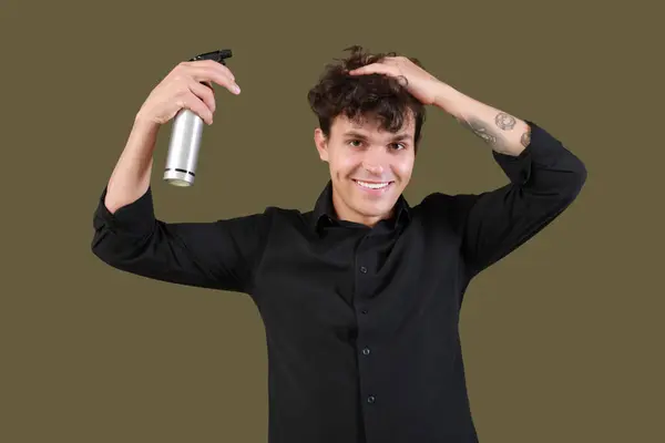 Pemuda Tampan Menerapkan Hair Spray Pada Rambutnya Keriting Terhadap Latar — Stok Foto