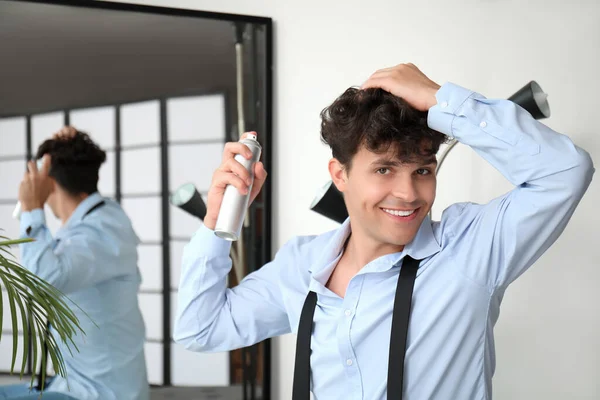 Yakışıklı Genç Adam Aynanın Yanındaki Kıvırcık Saçlarına Saç Spreyi Sıkıyor — Stok fotoğraf