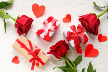 Kağıt kalpli güzel güller ve beyaz arka planda hediye kutuları. Sevgililer Günü kutlaması