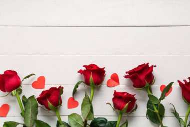 Beyaz ahşap arka planda kağıt kalpli güzel güller. Sevgililer Günü kutlaması