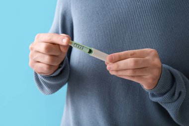 Mavi arka planda tükenmez kalem kullanan diyabetik genç adam.