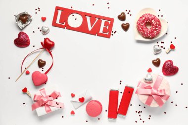 Farklı tatlardan yapılmış çerçeve, hediye kutuları ve beyaz arka planda aşk kelimesi. Sevgililer Günü kutlaması