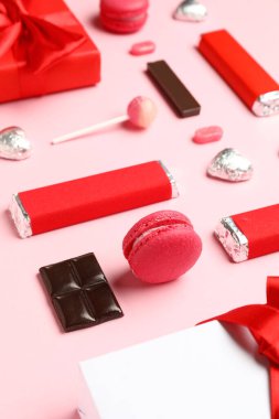 Farklı lezzetli tatlılar ve pembe arka planda hediye kutuları. Sevgililer Günü kutlaması