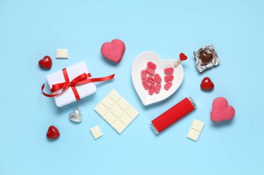 Mavi arka planda hediye kutusu olan farklı tatlılar. Sevgililer Günü kutlaması