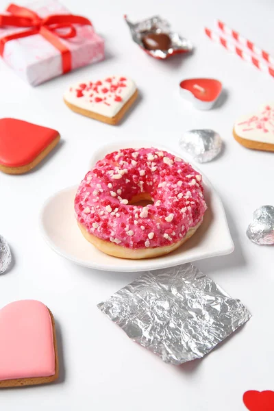 Different tasty sweets, gift box and plate with donut on white background. Valentine\'s Day celebration