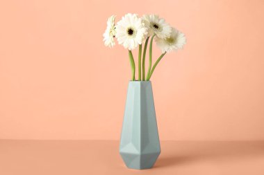 Çırılçıplak arkaplanda güzel Gerbera çiçekleri olan vazo