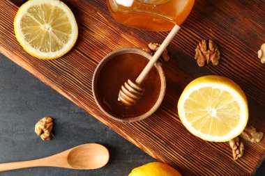 Bir kase tatlı bal ve masada limon.