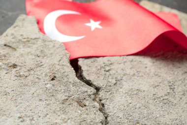 Koyu arkaplanda Türk bayrağı olan taş döküntüleri, yakın plan. Türkiye deprem kavramı