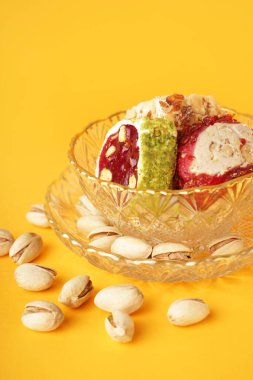 Sarı arka planda lezzetli Türk Lokumu olan kase, yakın plan.