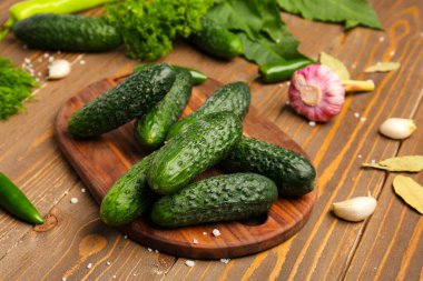 Ahşap arka planda taze salatalık korunması için kurulmuş.