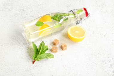 Limonlu bir şişe taze limonata ve nane şekeri.