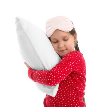 Beyaz arka planda uyku maskesi ve yumuşak yastıklı küçük kız.