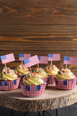 Lezzetli vatansever keklerle ahşap tezgah ve siyah ahşap masada Amerikan bayrağı. Amerikan Bağımsızlık Günü