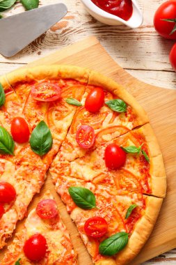 Beyaz ahşap arka planda lezzetli pizza margaritası olan bir pano.