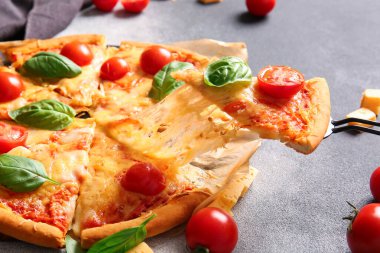 Gri arka planda lezzetli bir pizza margaritası olan fırın kağıdı.