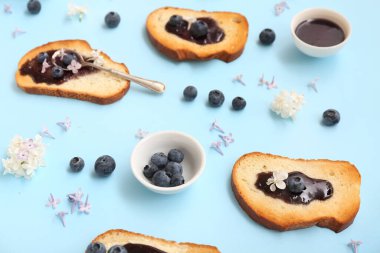 Lezzetli reçelli tost, mavi arka planda yabanmersini ve çiçekli kompozisyon