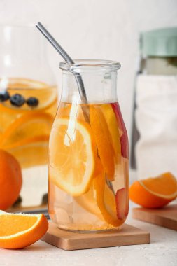 Beyaz masada portakal dilimli şişeler.