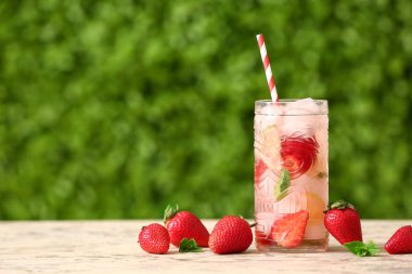 Dışarıdaki beyaz masada çilekli limonata.