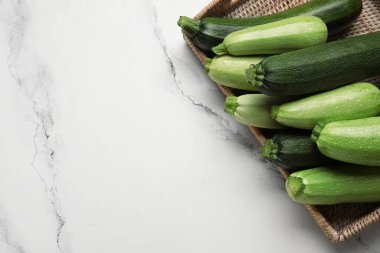 Beyaz mermer zemin üzerinde taze kabak ile hasır tepsi