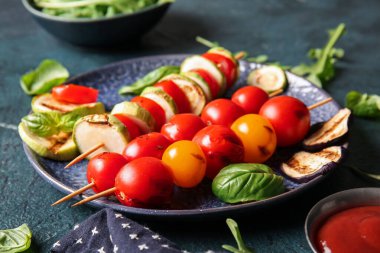 Mavi arka planda lezzetli ızgara sebzeli tabak.