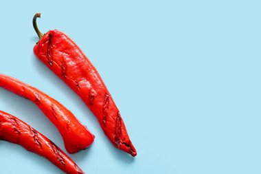 Mavi arka planda ızgara kırmızı biber.