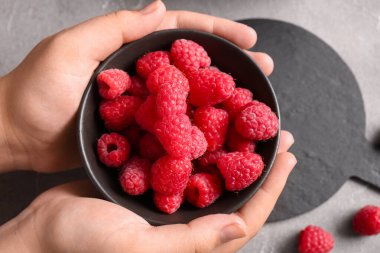 Taze ahududu tutan kadın eller, yakın plan.