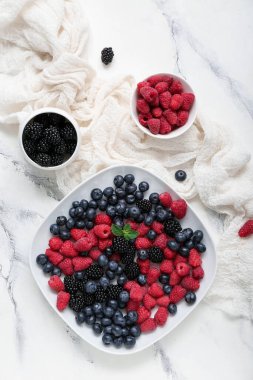 Açık arkaplanda farklı taze böğürtlen kompozisyonu