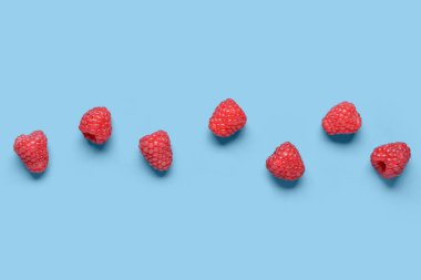 Mavi arka planda bir sürü taze ahududu