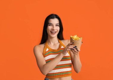 Turuncu arka planda patates kızartması olan güzel bir kadın.