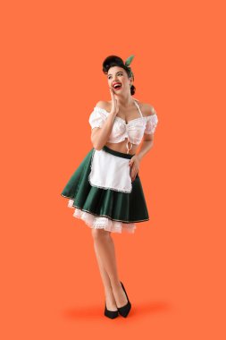 Young pin-up waitress on orange background
