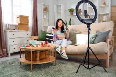 Kadın Asyalı güzellik blogcusu, evinde video kaydediyor.