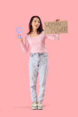 Genç Asyalı kız elinde kağıt ve pembe arka planda cinsiyet sembolü var.