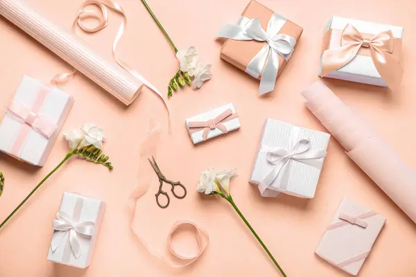 Komposition Mit Geschenkschachteln Geschenkpapier Und Freesiablüten Auf Nudefarbenem Hintergrund — Stockfoto