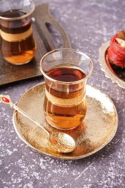 Glass of Turkish tea on grey background