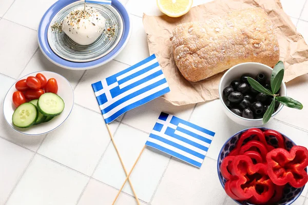 Flags of Greece and different food on tiled table